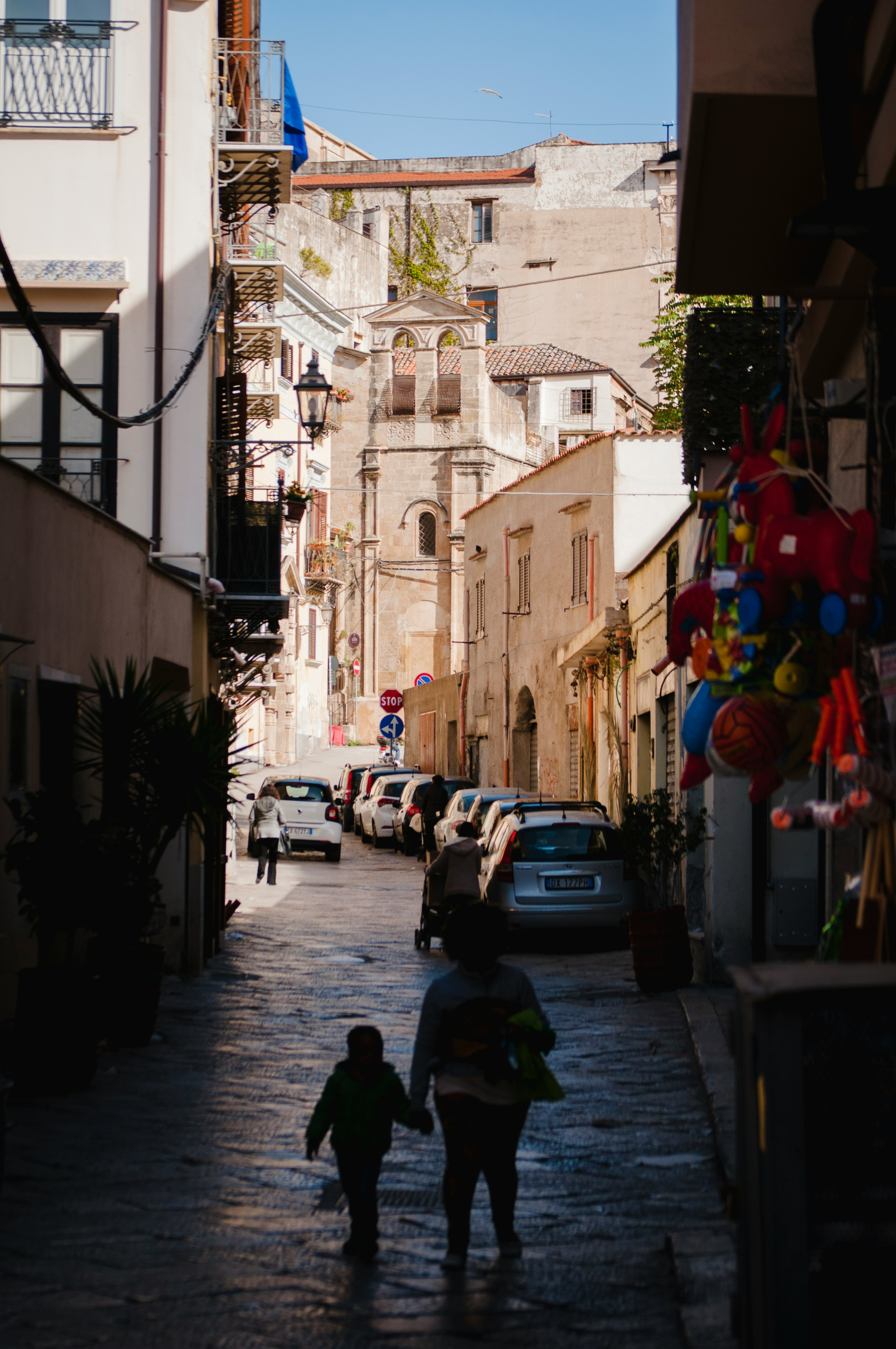 woman and boy walking on alley during daytime